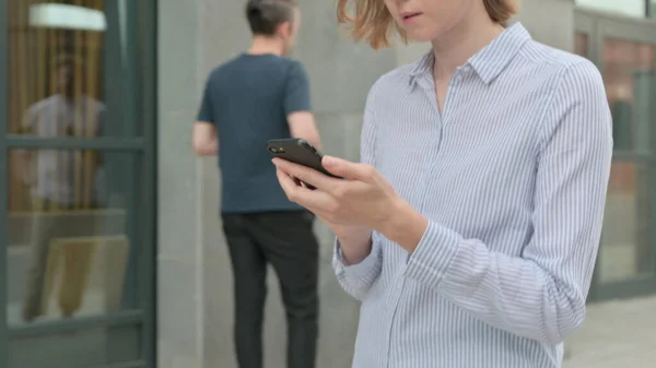 Gehende Frau nutzt Smartphone, surft im Internet — Stockfoto