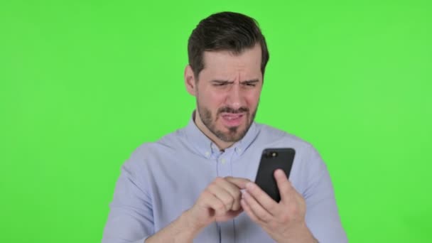 Portrait of Man Reacting to Loss on Smartphone, Green Screen — стоковое видео