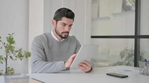 Fiatal férfi használja Tablet, miközben ül az irodában — Stock Fotó