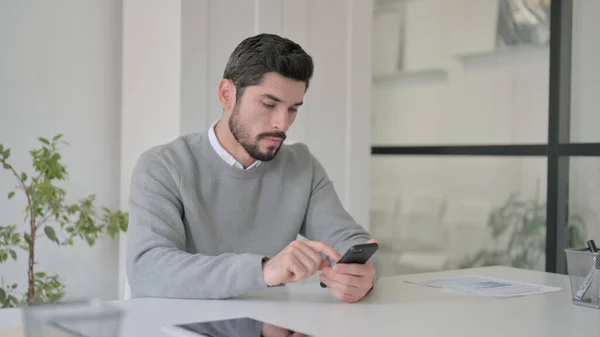 Jeune homme utilisant un smartphone au bureau — Photo