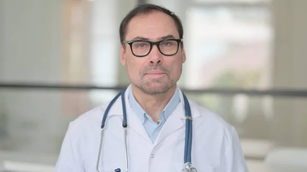 Arzt mittleren Alters blickt in die Kamera — Stockfoto