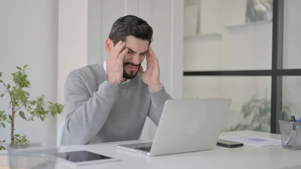 Junger Mann hat Kopfschmerzen bei der Arbeit am Laptop — Stockfoto