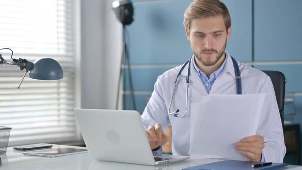 Läkare med Laptop Läsdokument på kliniken — Stockfoto