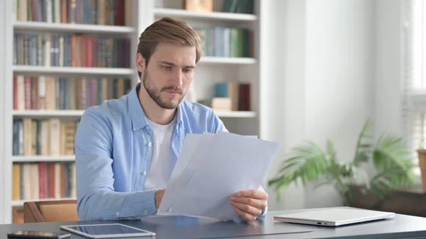 Mann liest Dokumente im Amt — Stockfoto