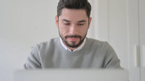 Närbild av ung man som arbetar på laptop — Stockfoto
