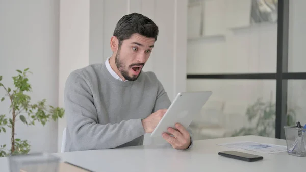 Junger Mann reagiert auf Verlust im Büro mit Tablet — Stockfoto