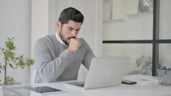 Fiatal férfi köhögés használata közben Laptop az irodában — Stock Fotó