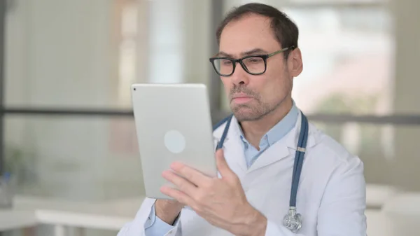 Доктор средних лет с помощью цифрового планшета — стоковое фото