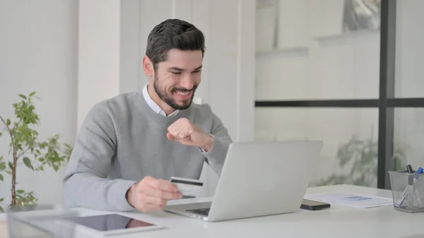 Giovane uomo che effettua il pagamento online di successo sul computer portatile — Foto Stock