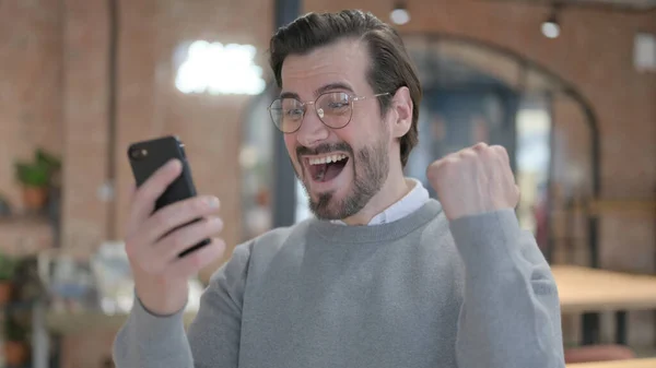 Jeune homme célébrant sur Smartphone — Photo