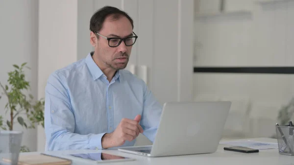 Człowiek w średnim wieku Rozmowa na wideo Połączenie na laptopie w biurze — Zdjęcie stockowe