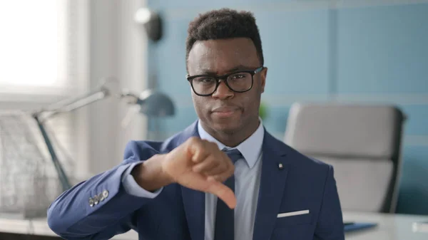 Portrét afrického podnikatele ukazující gesto palce dolů — Stock fotografie