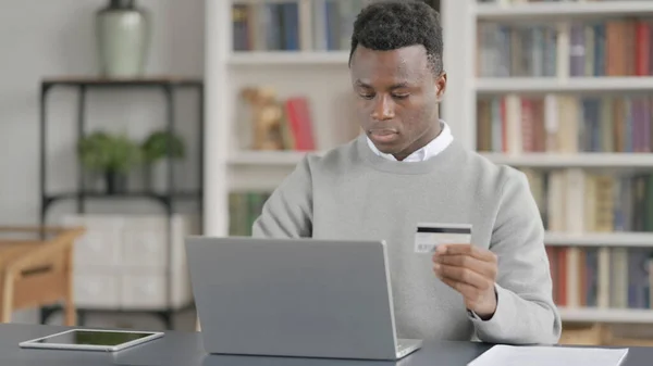 アフリカ人男性がラップトップでオンライン決済を行う — ストック写真