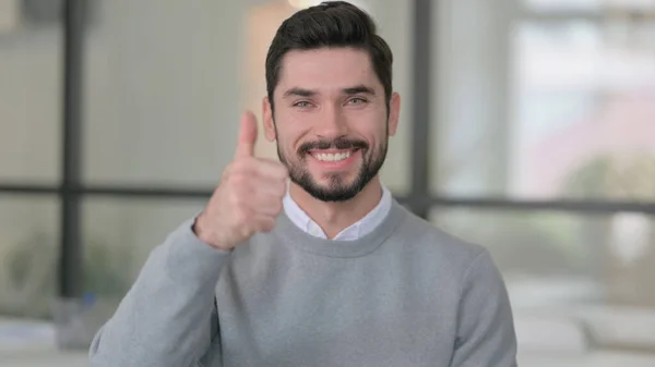 Retrato de un joven mostrando el signo de pulgares hacia arriba — Foto de Stock