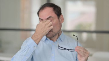Orta yaşlı adamın baş ağrısı var.