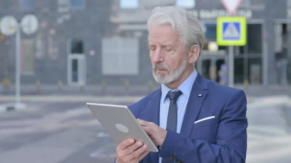 Vieux homme d'affaires utilisant la tablette tout en restant debout à l'extérieur — Photo