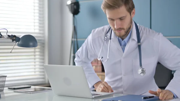 Dokter komt terug en opent laptop in de kliniek — Stockfoto