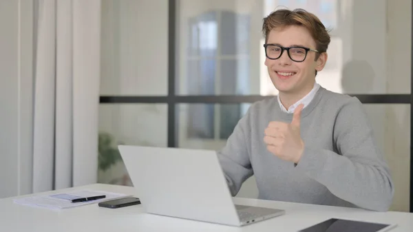 İşyerinde dizüstü bilgisayar kullanırken İşaret İşareti Gösteren Genç Adam — Stok fotoğraf