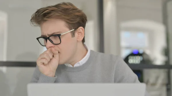 Nahaufnahme eines jungen Mannes, der während der Arbeit am Laptop hustet — Stockfoto