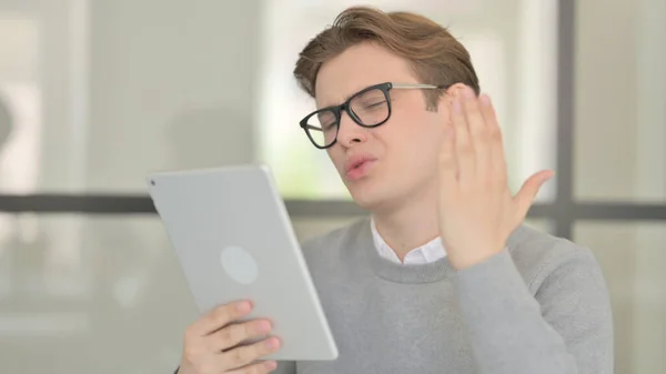 Hombre joven reaccionando a la pérdida en la tableta en la oficina moderna — Foto de Stock