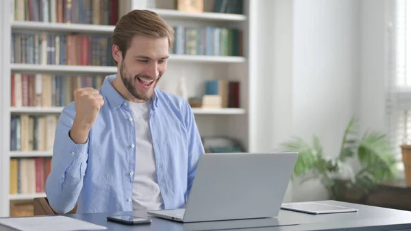 Mann feiert Erfolg mit Laptop im Büro — Stockfoto