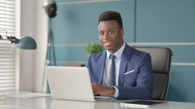 Dizüstü bilgisayarı olan Afrikalı Adam evet işareti olarak başını sallıyor. 