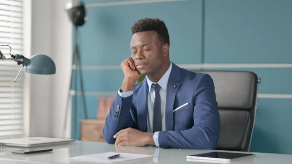 Ospalý africký podnikatel si zdřímne, zatímco sedí v kanceláři — Stock fotografie