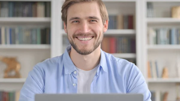 Primer plano del hombre sonriendo mientras usa el ordenador portátil — Foto de Stock