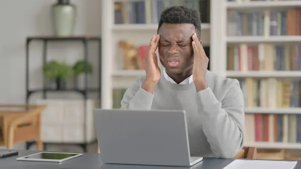 Afričan Muž s bolestí hlavy při práci na notebooku — Stock fotografie