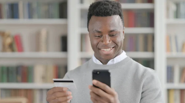 Portrét Afrického muže, který provádí online platbu na Smartphone — Stock fotografie