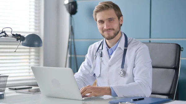 Médico sacudiendo la cabeza como ninguna señal mientras usa el ordenador portátil —  Fotos de Stock