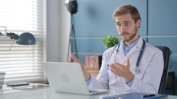 Doctor hablando en videollamada en el ordenador portátil en la clínica — Foto de Stock