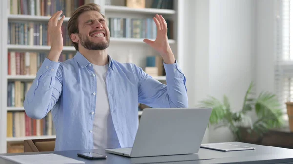 Homem celebrando ao usar o portátil no escritório no banco — Fotografia de Stock