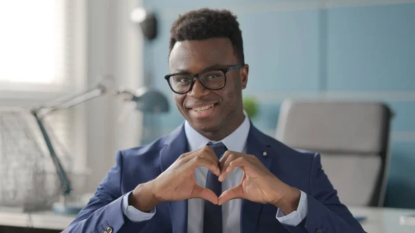 Porträtt av afrikansk affärsman visar hjärta form av händer — Stockfoto