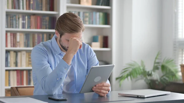 Homem reagindo a perda no tablet enquanto sentado no escritório — Fotografia de Stock