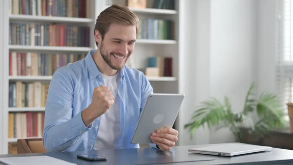 Uomo che celebra il successo sul tablet in ufficio — Foto Stock