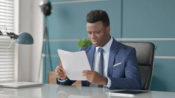 Afrikansk affärsman upprörd när du läser dokument i Office — Stockfoto