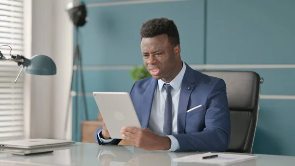 Empresário Africano Reagindo à Perda no Tablet enquanto sentado no escritório — Fotografia de Stock