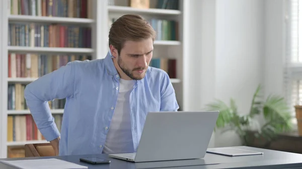 Man met rugpijn tijdens het gebruik van Laptop in Office — Stockfoto