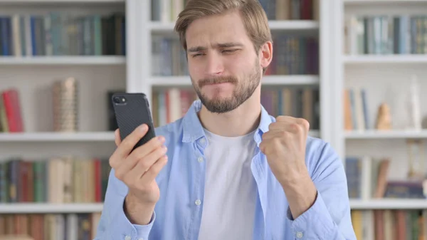 Retrato del hombre reaccionando a la pérdida en el Smartphone —  Fotos de Stock