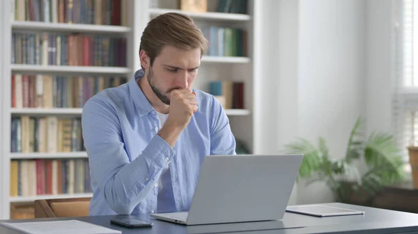Hombre tosiendo mientras usa el ordenador portátil en la oficina — Foto de Stock