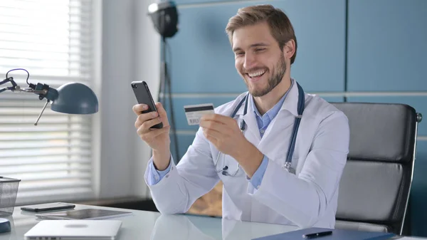 Médico haciendo el pago en línea en Smartphone en la clínica —  Fotos de Stock