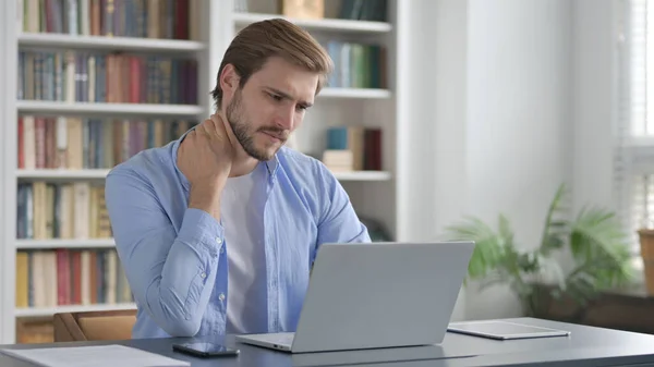 Man met nekpijn tijdens het typen op laptop — Stockfoto