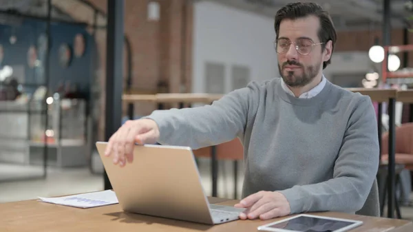 Giovane uomo chiusura del computer portatile e lasciando Cafe — Foto Stock