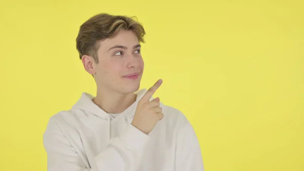 Young Man Pointing on Side on Yellow Background — Stock fotografie