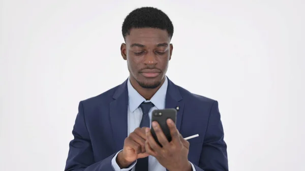 アフリカのビジネスマンが白い背景にスマートフォンを閲覧 — ストック写真