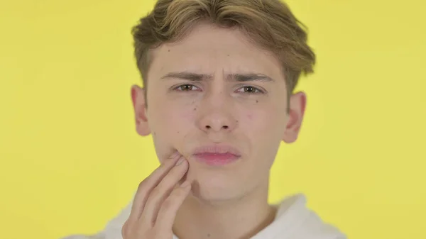 歯痛を持つ若い男のクローズアップ,黄色の背景 — ストック写真
