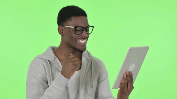 Afrikansk man firar framgång på Tablet på grön bakgrund — Stockfoto