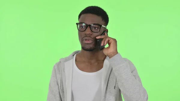 Hombre africano hablando por teléfono sobre fondo verde —  Fotos de Stock