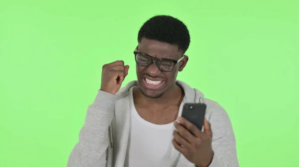 녹색 배경에 스마트폰으로 잃은 아프리카 남자 — 스톡 사진